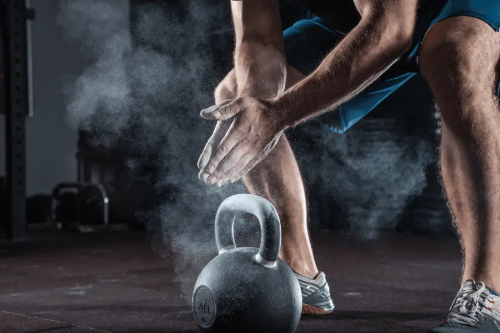 How Often Do MMA Fighters Lift Weights? 🏋️♂️ (With A Head Trainer's Perspective) Man with kettlebell which demonstrates how often do MMA fighters lift weights